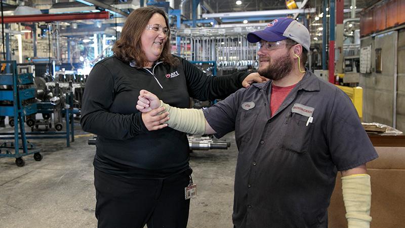 Physical therapist with an employee in a factory