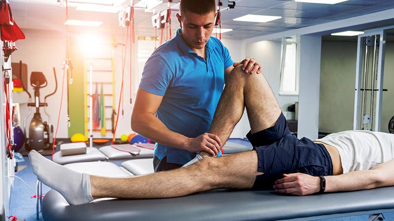 Therapist adjusting a patient's leg