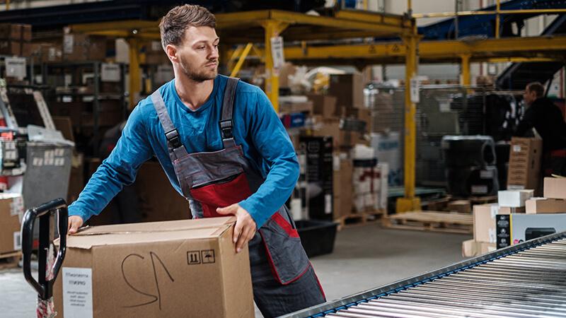 Employee moving a box in a plant